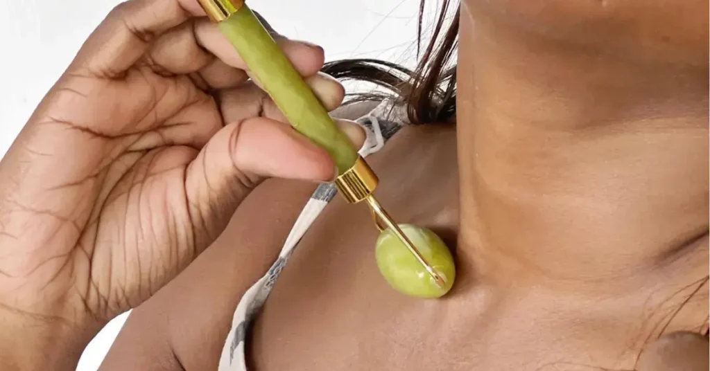 Black woman using jade roller on her neck