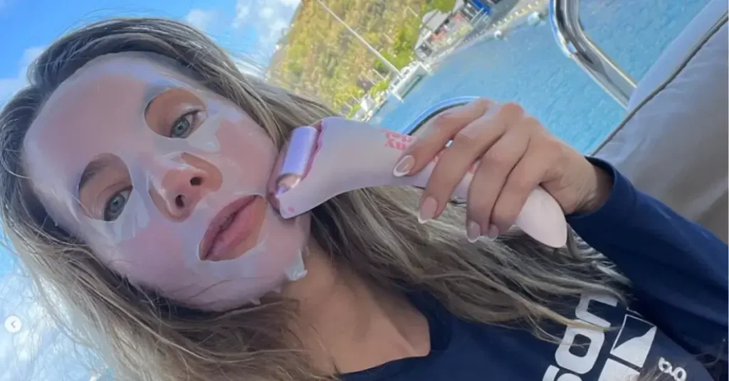 woman with face mask using ice roller outside