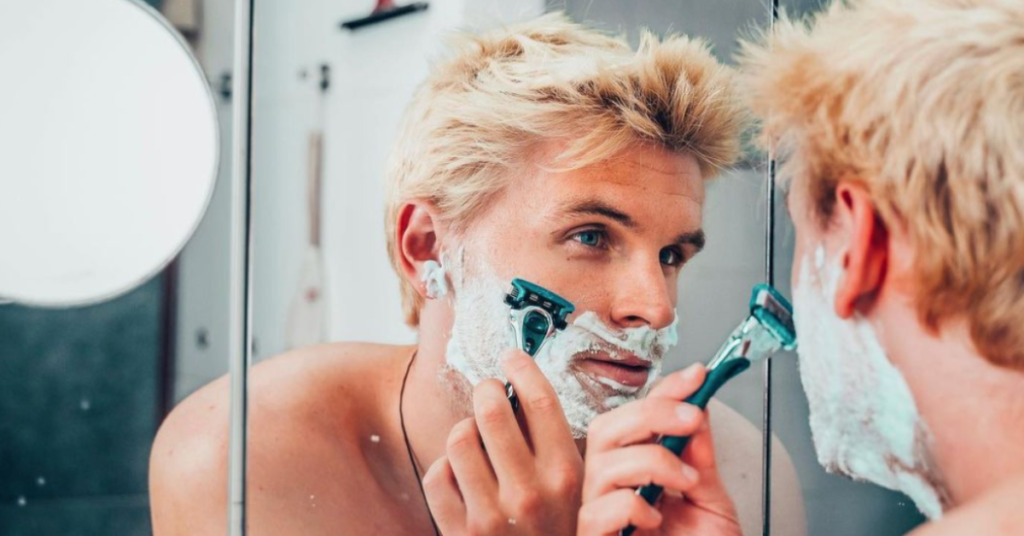young blonde man shaving