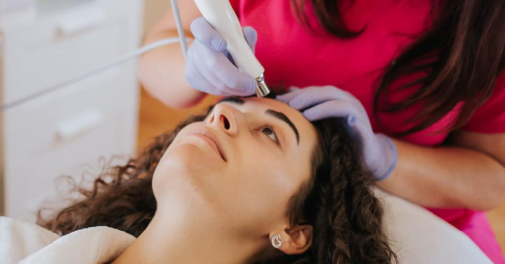 woman in pink t-shirt performing microdermabrasion treatment