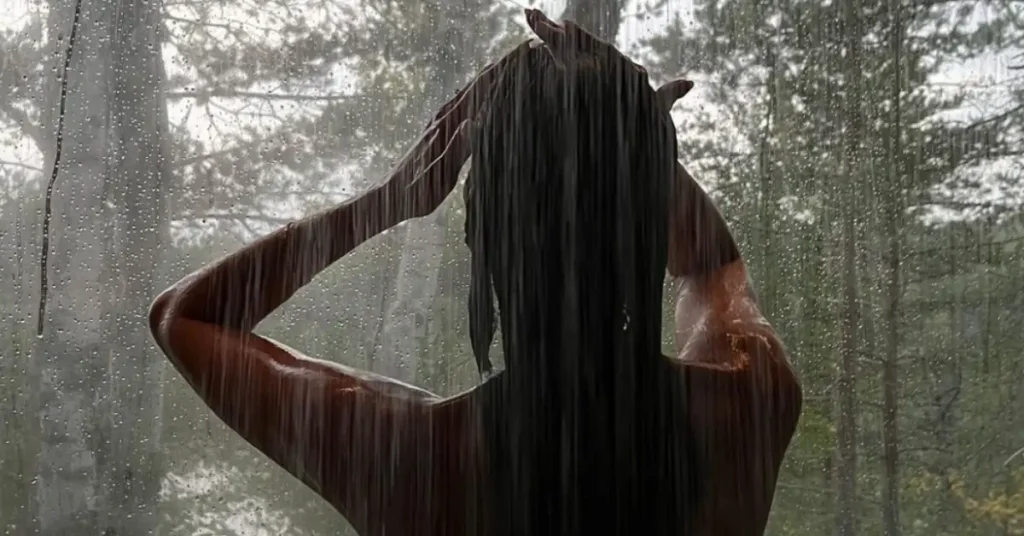 young brunette woman showering in the woods