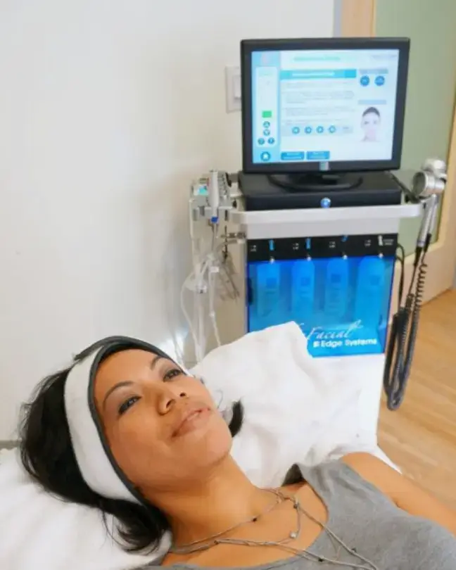 black haired woman and hydrafacial machine