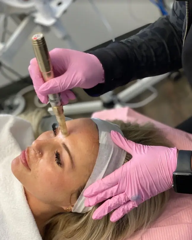 Woman with pink gloves doing a hydrafacial treatment