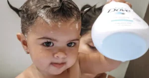 baby holding dove shampoo bottle